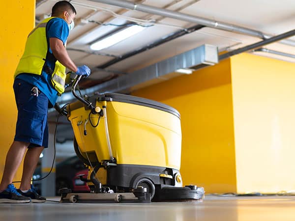 cleaning professional working in garage cleaning with sweeping m